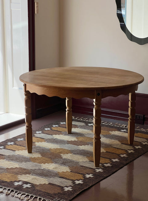 Vintage round wooden dining table with wavy/scalloped details