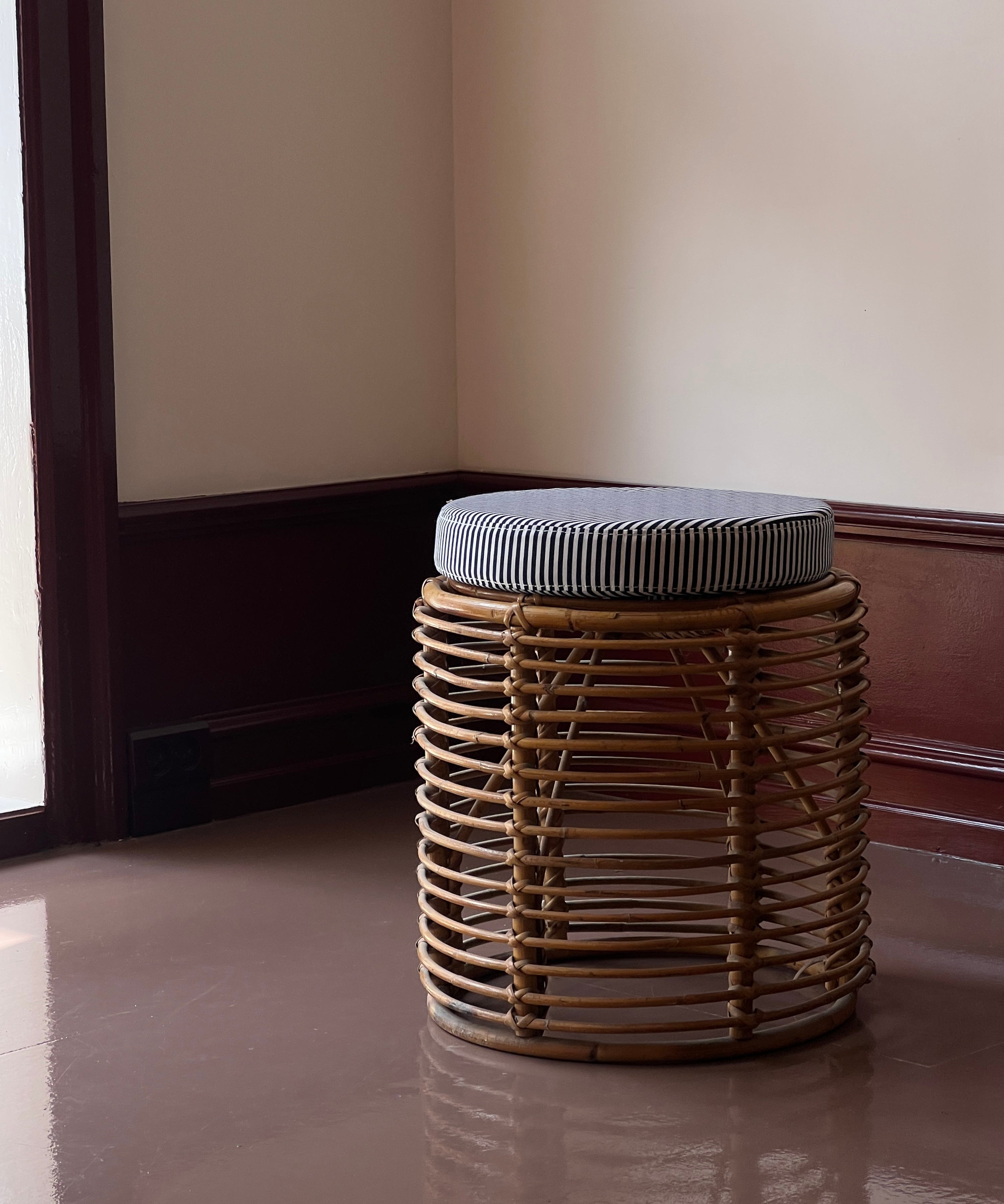 Vintage rattan stool with striped cushion