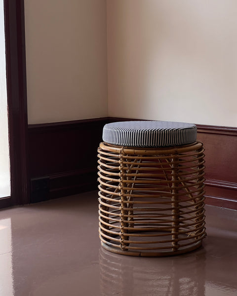 Vintage rattan stool with striped cushion