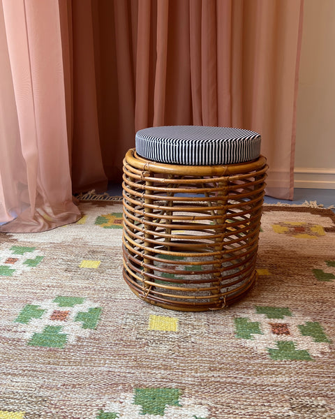 Vintage rattan stool with striped cushion