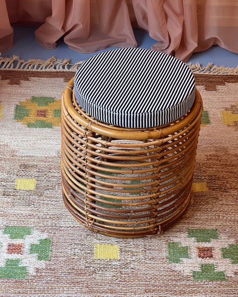 Vintage rattan stool with striped cushion