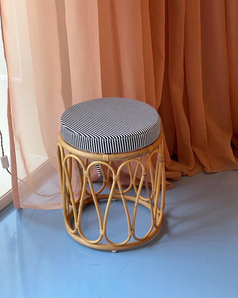 Rattan stool with striped cushion